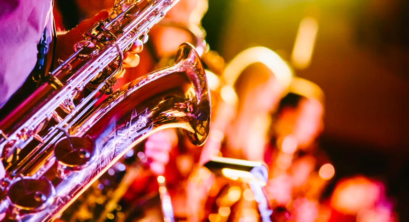 Brightly colored close-up of a saxophone and band