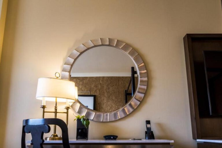 Hotel dresser with a round mirror hanging over it