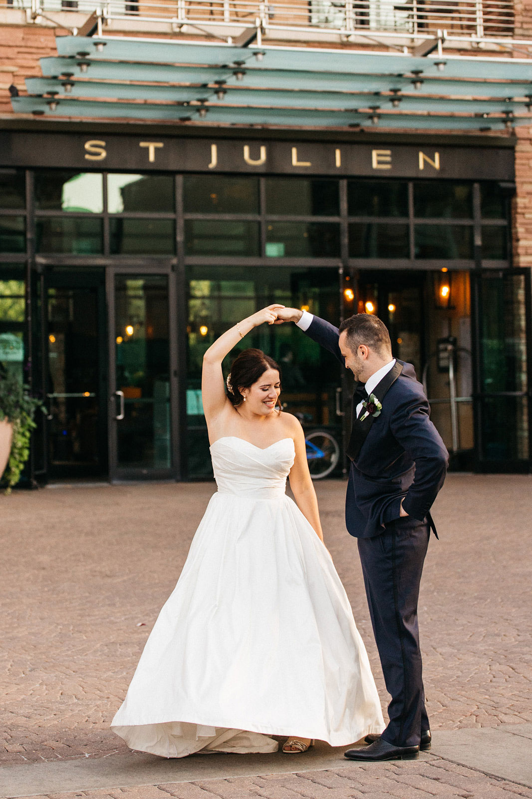 groom and bride dancing in front of st julien hotel entrance