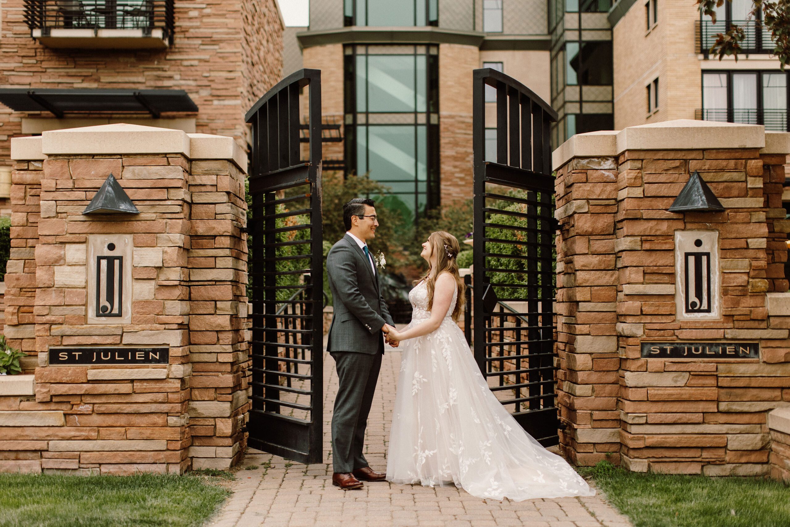 groom and bride pose on gates on st julien hotel